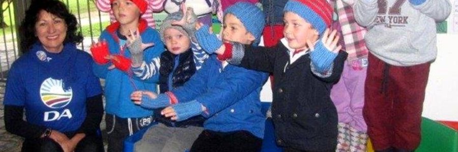 Die kleuters by Cool Kids is duidelik beïndruk met hulle mussies en handskoene, met rdl Riana de Coning by hulle.  